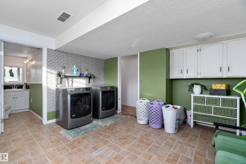 Washroom featuring washer and clothes dryer and a textured ceiling - 145 Plum Crescent, Wetaskiwin, AB - Indoor Photo Showing Laundry Room