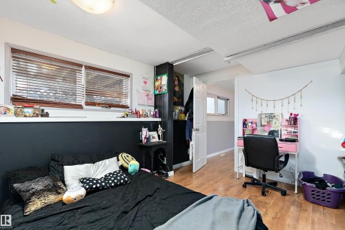 Bedroom featuring light wood-style floors, a desk, and a textured ceiling - 145 Plum Crescent, Wetaskiwin, AB - Indoor