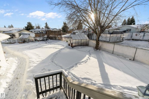 Snowy yard with a greenhouse, an outbuilding, a fenced backyard, and a residential view - 145 Plum Crescent, Wetaskiwin, AB - Outdoor