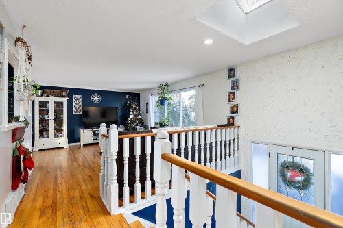 Hall featuring an upstairs landing, a skylight, light wood-style flooring, a textured wall, and recessed lighting - 145 Plum Crescent, Wetaskiwin, AB - Indoor Photo Showing Other Room