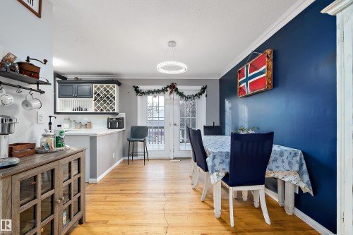 Dining area featuring ornamental molding and light wood finished floors - 145 Plum Crescent, Wetaskiwin, AB - Indoor Photo Showing Dining Room