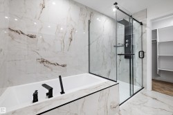Full bathroom featuring marble tiled floors, a marble finish shower, a garden tub, and a spacious closet - 