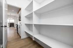 Spacious closet featuring a chandelier and light wood-type flooring - 