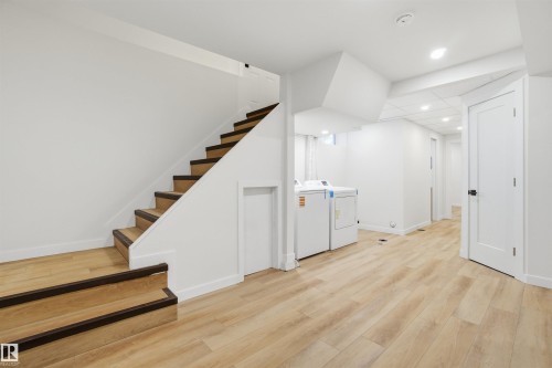 Finished basement with light wood-style flooring, independent washer and dryer, stairway, and recessed lighting - 5711 95 Avenue, Edmonton, AB - Indoor Photo Showing Other Room
