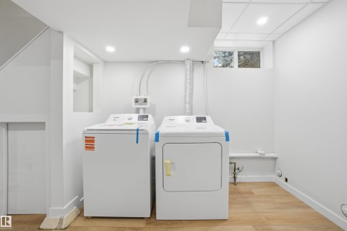 Washroom featuring light wood-style floors, washing machine and clothes dryer, recessed lighting, and elevator - 5711 95 Avenue, Edmonton, AB - Indoor Photo Showing Laundry Room