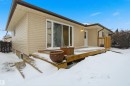 Snow covered house featuring a wooden deck - 5711 95 Avenue, Edmonton, AB  - Outdoor With Deck Patio Veranda With Exterior 