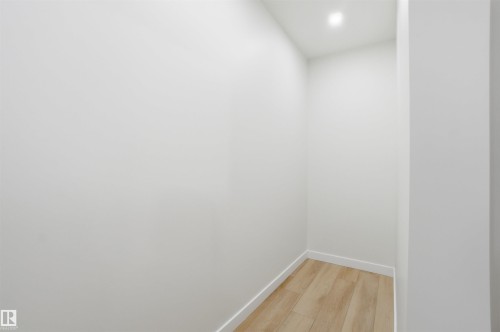 Unfurnished room with light wood-type flooring and baseboards - 5711 95 Avenue, Edmonton, AB - Indoor Photo Showing Other Room