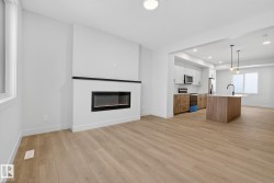 Kitchen with brown cabinets, an island with sink, light countertops, open floor plan, and recessed lighting - 