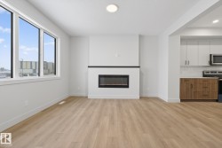 Unfurnished living room with light wood finished floors, a glass covered fireplace, and recessed lighting - 