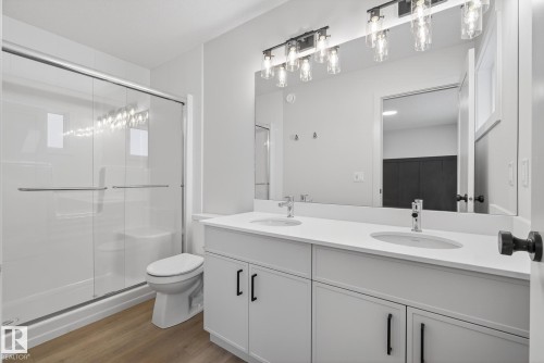 Bathroom with double vanity, a stall shower, and wood finished floors - 119 Brickyard Drive, Stony Plain, AB - Indoor Photo Showing Bathroom