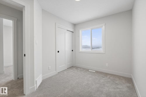 Unfurnished bedroom featuring light carpet and a closet - 119 Brickyard Drive, Stony Plain, AB - Indoor Photo Showing Other Room