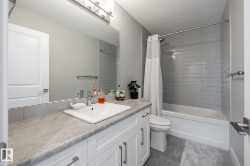 Bathroom featuring shower / tub combo, a textured ceiling, and vanity - 1440 Darby Green, Edmonton, AB - Indoor Photo Showing Bathroom