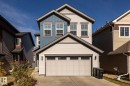 View of front facade with board and batten siding, driveway, and a garage - 1440 Darby Green, Edmonton, AB  - Outdoor 