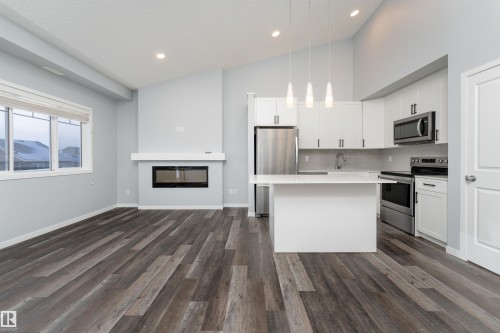 56 3305 Orchards Link Sw, Edmonton, AB - Indoor Photo Showing Kitchen With Fireplace With Stainless Steel Kitchen