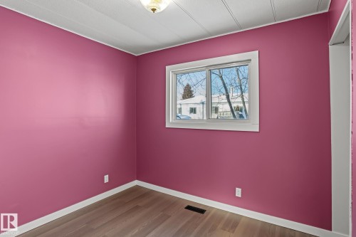 Empty room featuring dark wood-style flooring and baseboards - 315 10 Street, Cold Lake, AB - Indoor Photo Showing Other Room