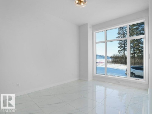 Main floor bedroom with light marble finish floors and baseboards - 6131 Crawford Drive, Edmonton, AB - Indoor Photo Showing Other Room