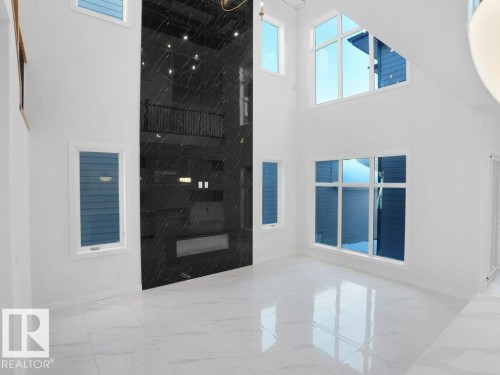 Interior space with light marble finish flooring, healthy amount of natural light, and a high ceiling - 6131 Crawford Drive, Edmonton, AB - Outdoor With Exterior