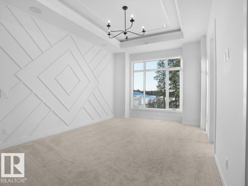 Unfurnished room featuring a chandelier, light carpet, and a tray ceiling - 6131 Crawford Drive, Edmonton, AB - Indoor Photo Showing Other Room