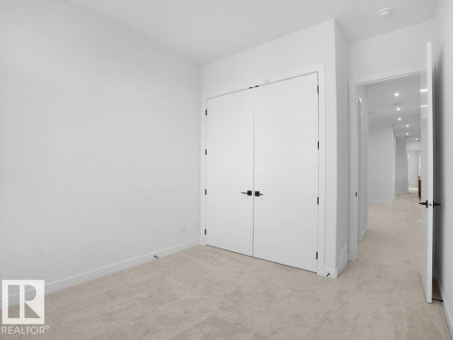 Unfurnished bedroom with light colored carpet and a closet - 6131 Crawford Drive, Edmonton, AB - Indoor Photo Showing Other Room
