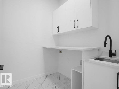 Washroom with light marble finish floors, hookup for a washing machine, and cabinet space - 6131 Crawford Drive, Edmonton, AB - Indoor