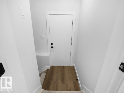 Stairway featuring baseboards and wood finished floors - 6131 Crawford Drive, Edmonton, AB - Indoor Photo Showing Other Room