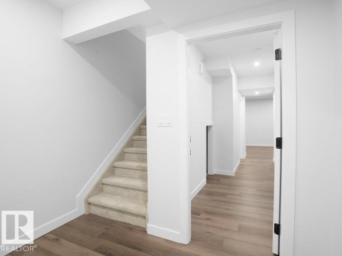Stairway with wood finished floors and baseboards - 6131 Crawford Drive, Edmonton, AB - Indoor Photo Showing Other Room