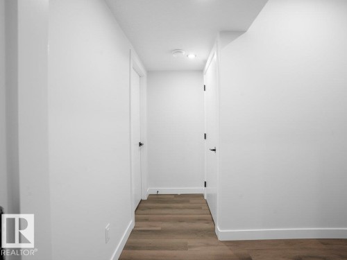 Hallway featuring baseboards and dark wood-style flooring - 6131 Crawford Drive, Edmonton, AB - Indoor Photo Showing Other Room