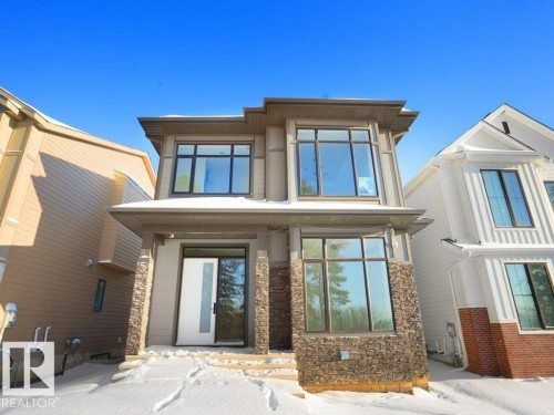 Snow covered house featuring stone siding - 6131 Crawford Drive, Edmonton, AB - Outdoor With Facade