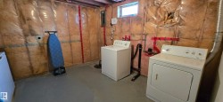 Washroom with concrete floors, washer and clothes dryer, and electric panel - 