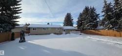 Snow covered rear of property featuring a fenced backyard - 