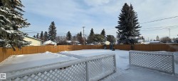 Yard layered in snow with a fenced backyard - 