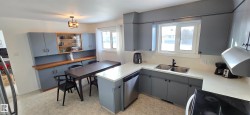 Kitchen with gray cabinetry, black / electric stove, decorative backsplash, and light countertops - 