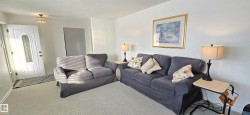 Living area with carpet flooring and baseboards - 