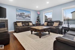 Living area with dark wood-type flooring, recessed lighting, and a tiled fireplace - 