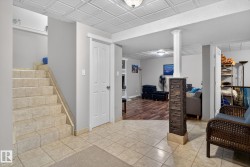 Finished below grade area featuring tile patterned floors, stairs, and an ornate ceiling - 