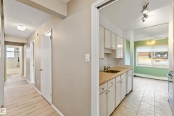 Kitchen with light countertops, white cabinetry, a ceiling fan, dishwasher, and a textured ceiling - 