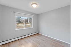 Spare room with baseboard heating, light wood-type flooring, and a textured ceiling - 
