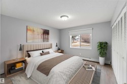 Bedroom with a closet, a textured ceiling, wood finished floors, and a baseboard heating unit - 