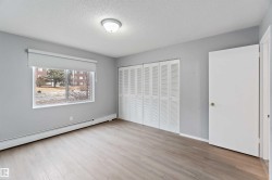 Unfurnished bedroom with a textured ceiling, light wood-style floors, a closet, and a baseboard heating unit - 