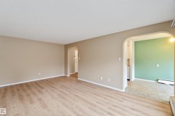 Spare room with light wood-style floors, baseboard heating, and arched walkways - 