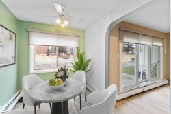 Dining room featuring a baseboard radiator, arched walkways, wood finished floors, and ceiling fan - 