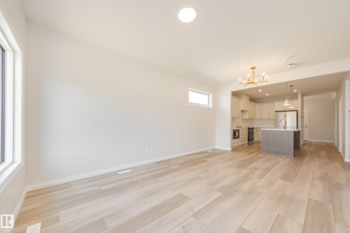 Unfurnished living room featuring recessed lighting, light wood-type flooring, and a chandelier - 199 Stonehouse Way, Leduc, AB - Indoor