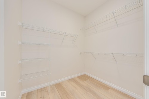 Walk in closet featuring light wood-style floors - 199 Stonehouse Way, Leduc, AB - Indoor With Storage
