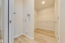 Washroom featuring light wood finished floors, washer hookup, and recessed lighting - 