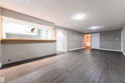 Unfurnished living room featuring wood finished floors, a textured ceiling, and washer / dryer - 