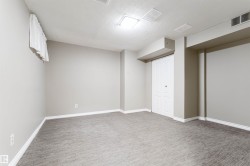 Finished below grade area with light colored carpet and a textured ceiling - 