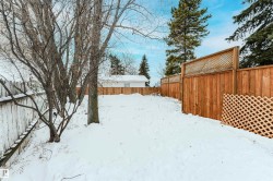 Yard layered in snow with a fenced backyard - 