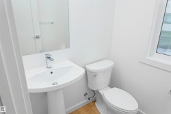 Half bathroom with toilet and light wood-style flooring - 