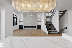 Unfurnished living room with built in features, a fireplace, light wood-style flooring, stairs, and recessed lighting - 