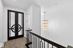 Carpeted entrance foyer with french doors and a chandelier - 
